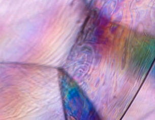 Colorful abstract patterns with iridescent swirls and smooth textures, resembling the surface of a soap bubble.