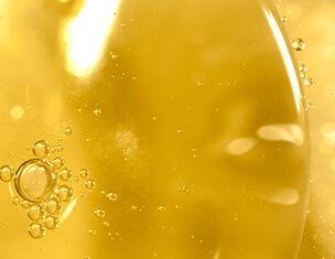 Primer plano de burbujas en un liquido amarillo, creando un efecto brillante y texturizado.