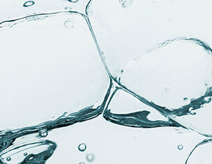 Cubitos de hielo sumergidos en agua clara, creando burbujas y reflejos.