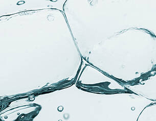 Cubitos de hielo sumergidos en agua clara, creando burbujas y reflejos.