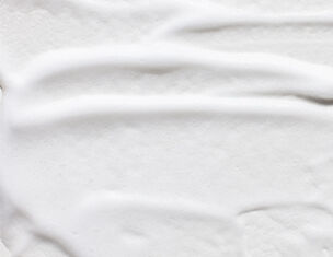 Textura cremosa blanca, lisa y suave, que sugiere un producto cosmetico o alimentario.
