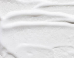 Textura cremosa blanca, lisa y suave, que sugiere un producto cosmetico o alimentario.