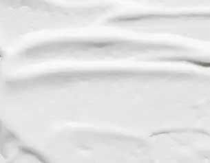 Textura cremosa blanca, lisa y suave, que sugiere un producto cosmetico o alimentario.