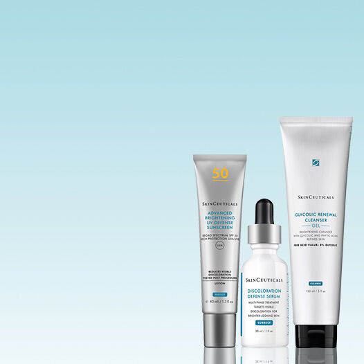 Tres productos de cuidado de la piel de SkinCeuticals: un limpiador, un serum y un protector solar en un fondo suave.