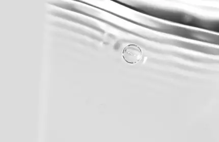 A smooth, silver-toned background with subtle ripples and bubbles, resembling the surface of water.