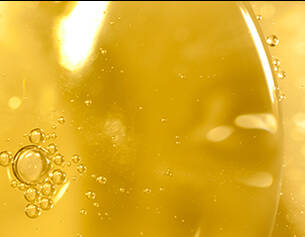 Primer plano de burbujas en un liquido dorado, creando un efecto luminoso y brillante.
