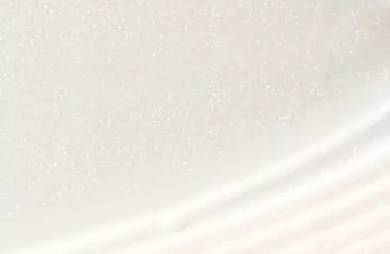 Close-up of a smooth, white surface with a subtle shimmer, featuring gentle curves and a textured edge.