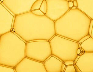 Estructura de burbujas amarillas en un patron hexagonal, mostrando detalles de su forma y superficie.