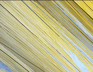 Textura de hojas de papel amarillas y azules dispuestas en angulo, creando un patron visual dinamico y abstracto.