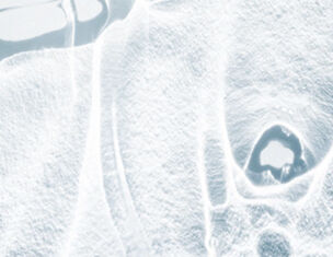 Abstract ice texture with smooth, reflective surfaces and intricate patterns, creating a cold, serene atmosphere.