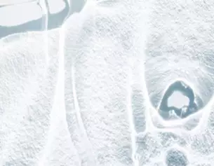 Abstract ice texture with smooth, reflective surfaces and intricate patterns, creating a cold, serene atmosphere.