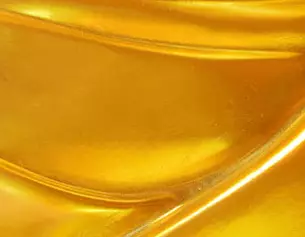 Textura suave y brillante en tonos dorados, con ondulaciones que reflejan la luz.