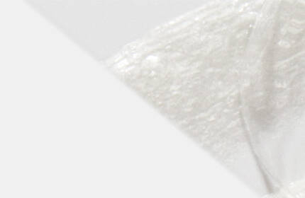 A close-up of a white, fluffy substance against a soft, light background, suggesting a texture that is smooth and airy.