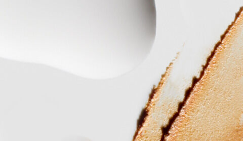 Alt text: Abstract composition featuring smooth white and textured beige surfaces with subtle water droplets.