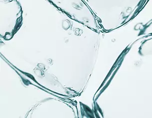 Burbujeas de aire flotando en agua transparente, con fragmentos de hielo en primer plano.