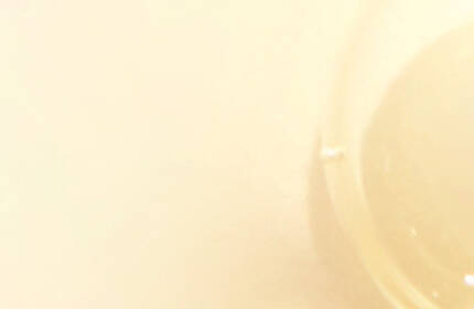 A close-up image of translucent, round bubbles on a soft, light background, creating a smooth and airy aesthetic.