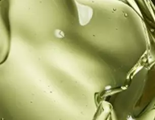 Aceite liquido de color verde claro, con burbujas y reflejos brillantes sobre un fondo suave.
