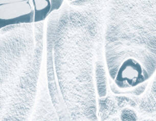 Textura de hielo azul claro con formas abstractas y reflejos en un fondo claro.