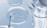 Instrumentos de laboratorio sobre una superficie reflejante, incluyendo un portaobjetos y un vaso medidor.