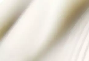 Textura suave de tela blanca que se pliega, creando un efecto ondulado y elegante.