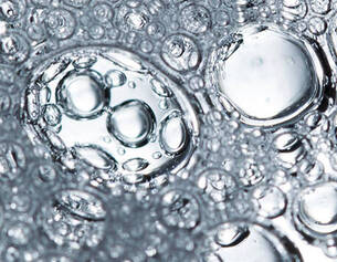 Close-up of clear water bubbles, featuring various sizes and reflections, creating a textured, immersive underwater effect.