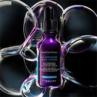 Tres serums de SkinCeuticals, iluminados desde atras.
