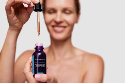 Una mujer esta a punto de aplicar el serum SkinCeuticals H.A. Intensifier.