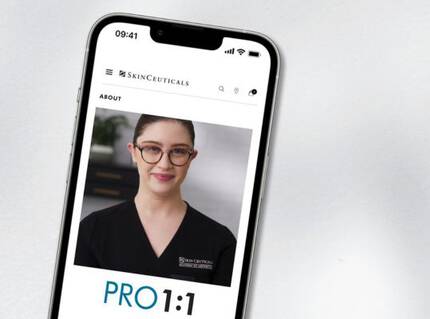 Una imagen de un telefono movil que muestra una pagina web con la foto de una persona que lleva una bata de medico. En la parte inferior se lee "PRO 1:1".