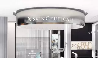 Texto alternativo: Imagen de un moderno espacio interior con un letrero colgante de SkinCeuticals en el techo, rodeado de un diseno elegante y contemporaneo.
