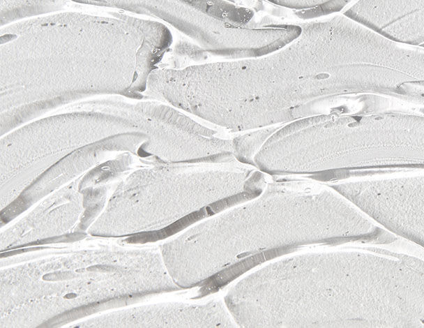 Close-up of a textured, translucent gel with wavy patterns, resembling a smooth, glossy surface.