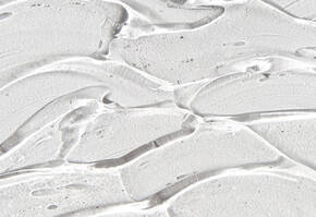 Close-up of a textured, translucent gel with wavy patterns, resembling a smooth, glossy surface.