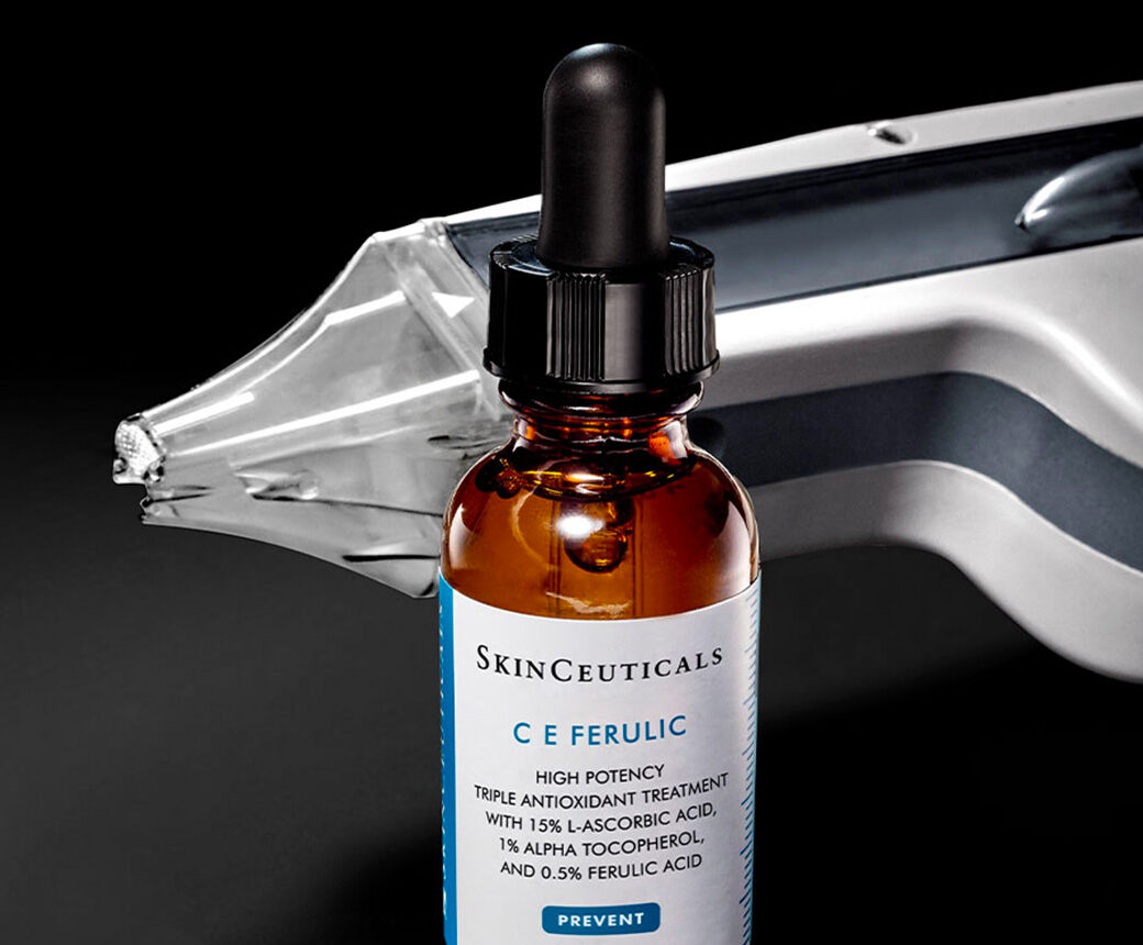 Frascos de sueros faciales sobre un fondo negro.