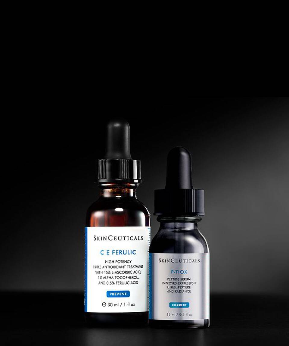 Sobre un fondo negro, se muestran dos tubos de muestra de 15 ml de los protectores solares SkinCeuticals con FPS 50: Ultra Facial UV Defense (izquierda) y Advanced Brightening UV Defense (derecha).
