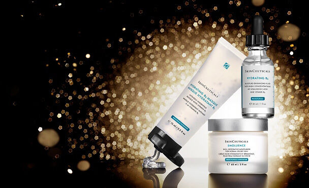 A collection of SkinCeuticals skincare products, including Hydrating B5 Masque, Hydrating B5 serum, and Emollience all set against a shimmering gold background.