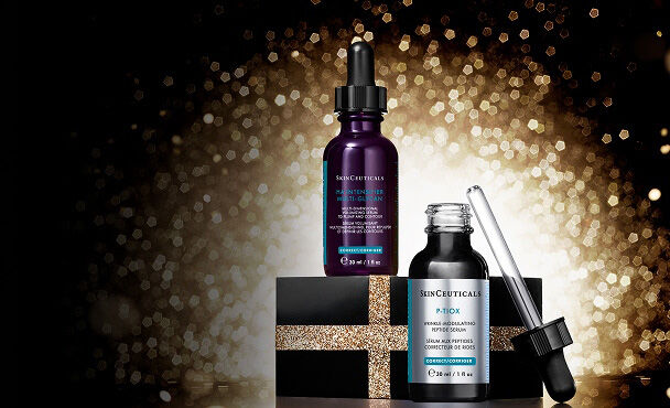 Una composicion de tres productos de cuidado de la piel de Skinceuticals, incluyendo un limpiador, un suero y una crema, sobre un fondo oscuro, con cintas negras decorativas.