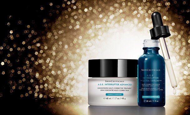 A collection of SkinCeuticals skincare products, including A.G.E. Interrupter Ultra Serum and A.G.E. Interrupter Advanced all set against a shimmering gold background.​