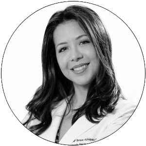 Una mujer sonriente con cabello largo y oscuro, vestida con una bata blanca, en un fondo circular negro y blanco.